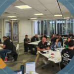 A group of participants engaged in a workshop at the Whakatupu Programme, collaborating and discussing in a bright, modern workspace.